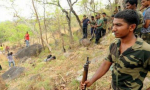 Members of the special combing squad stand near the body of a suspected red sanders smuggler who was shot dead, near Tirumala.