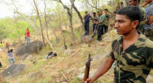 Members of the special combing squad stand near the body of a suspected red sanders smuggler who was shot dead, near Tirumala.